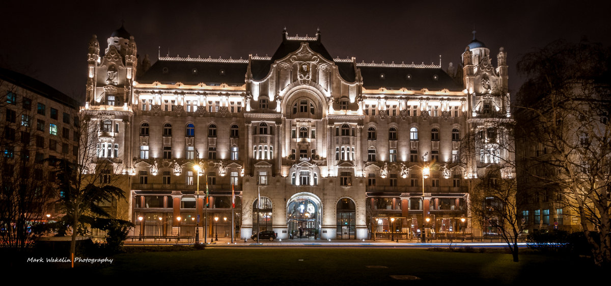 Grand historic building illuminated at night with ornate architectural details and lit windows.